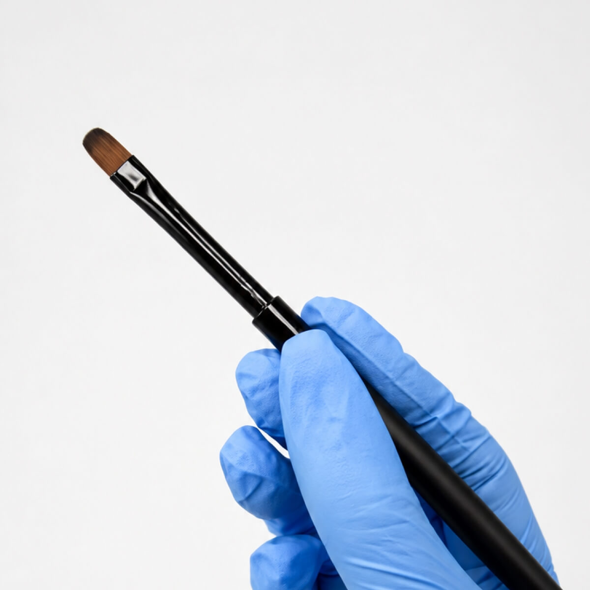 Kvadro Oval Nail Brush shown next to its protective cap for size reference