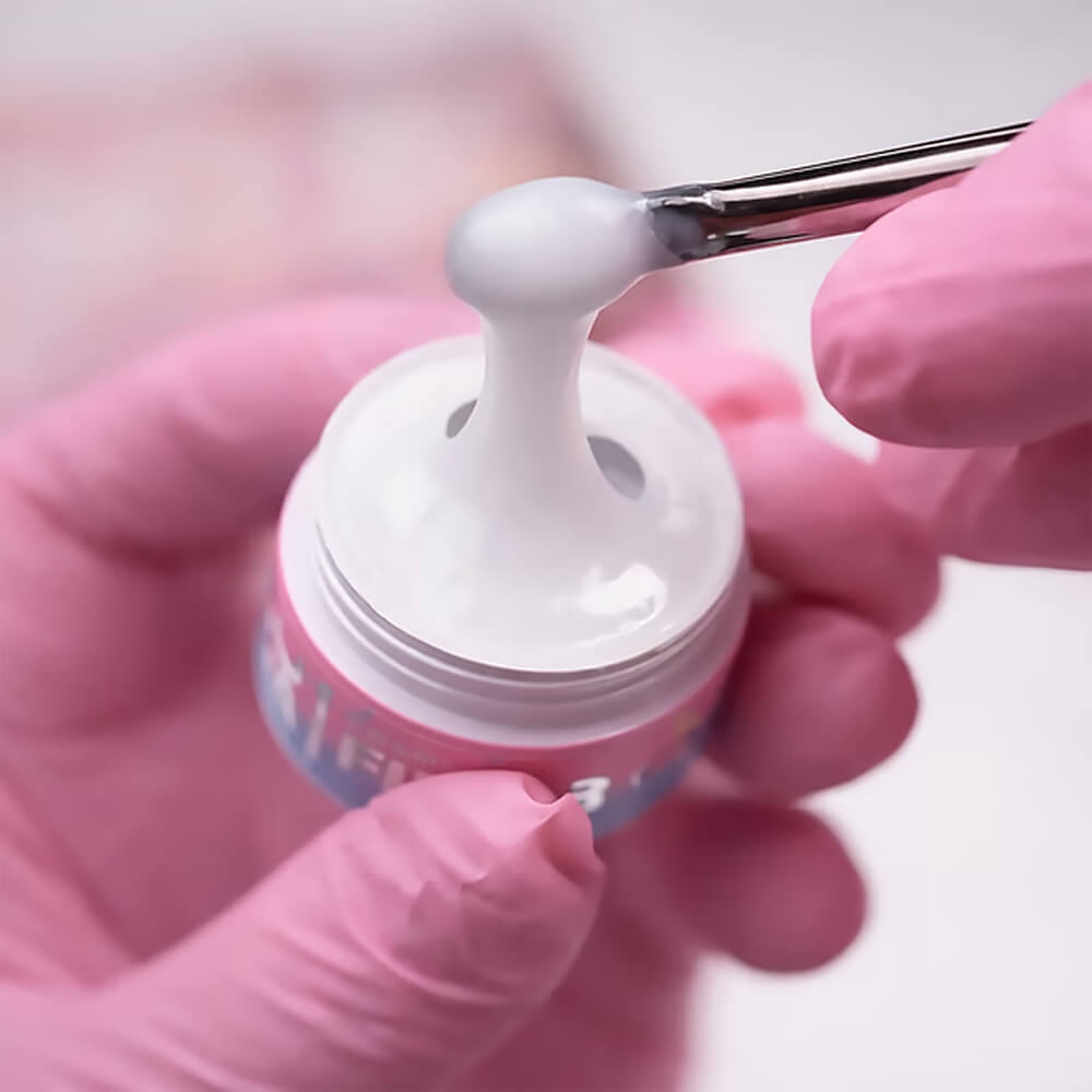 White fiber gel being applied to strengthen a brittle nail
