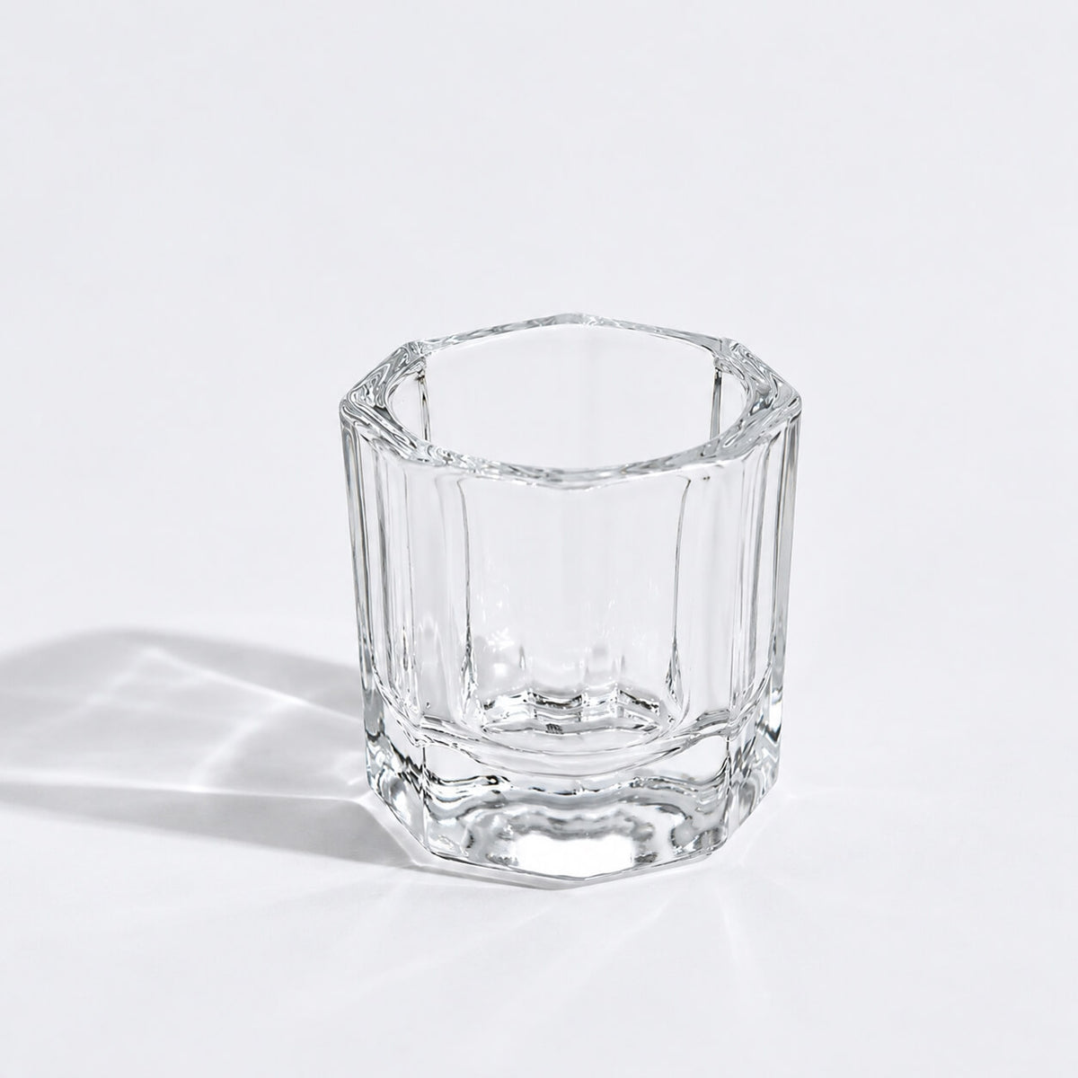 Transparent round nail crystal cup on a manicure table