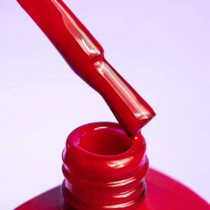 Nail technician applying DNKa Cover Base #0003 Passionate to a natural nail