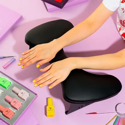 DNKa Anatomical Armrest for Manicure — black, in use during a manicure session