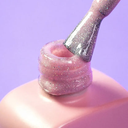 Nail technician applying DNKa Cover Base #0008 Magical to a natural nail