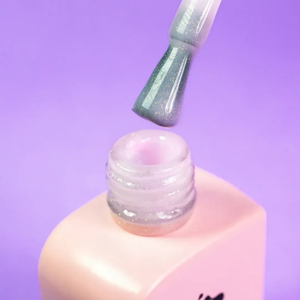Nail technician applying DNKa Cover Base #0010 Wonderful to a natural nail