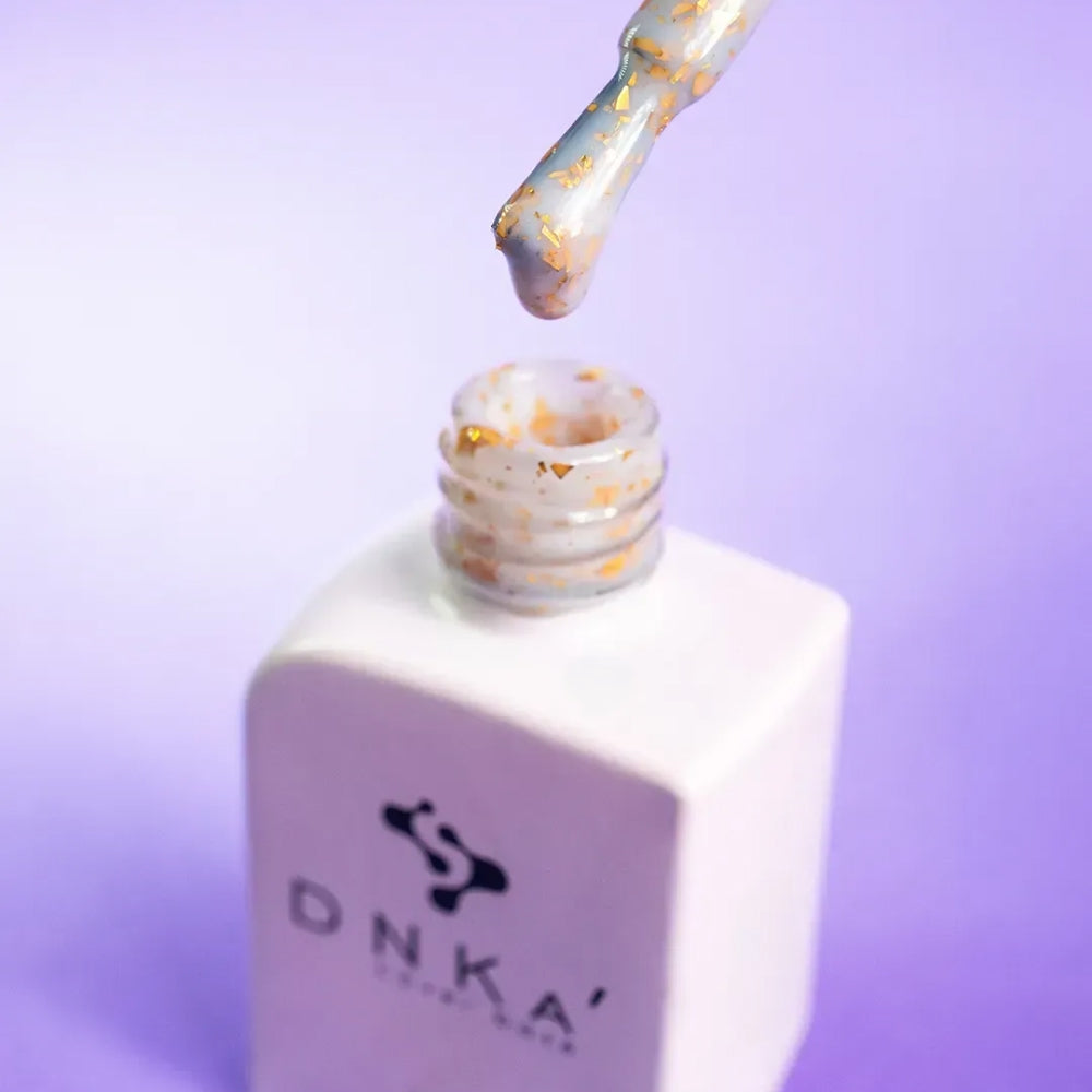 Close-up swatch showing the gold glitter in DNKa Cover Base #0011 Famous