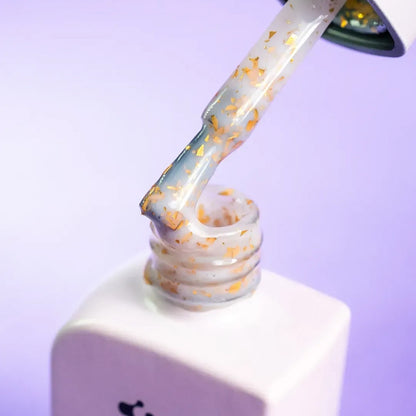 Nail technician applying DNKa Cover Base #0011 Famous to a natural nail