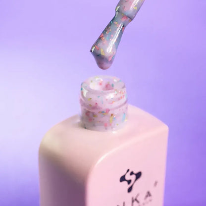 Nail technician applying DNKa Cover Base #0011B Beauttiful to a natural nail