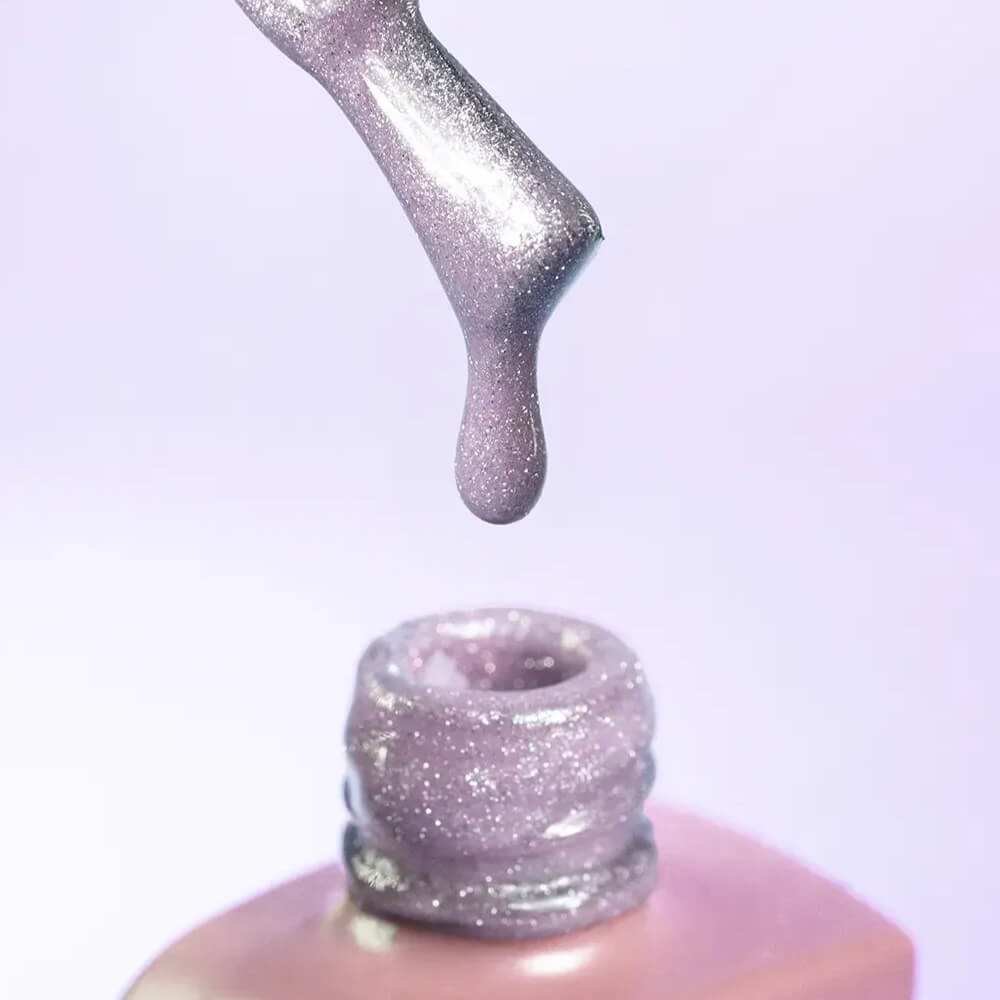 Nail technician applying DNKa Cover Base #0013 Amazing to a natural nail