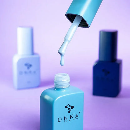 Nail technician applying DNKa Cover Base #0016 Sincere to a prepped nail plate