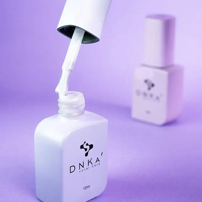 DNKa Cover Base #0023 Tender bottle held next to a manicured hand