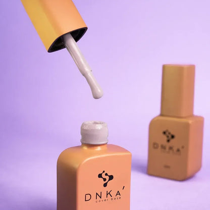 DNKa Cover Base #0032 Soulful bottle held next to a manicured hand