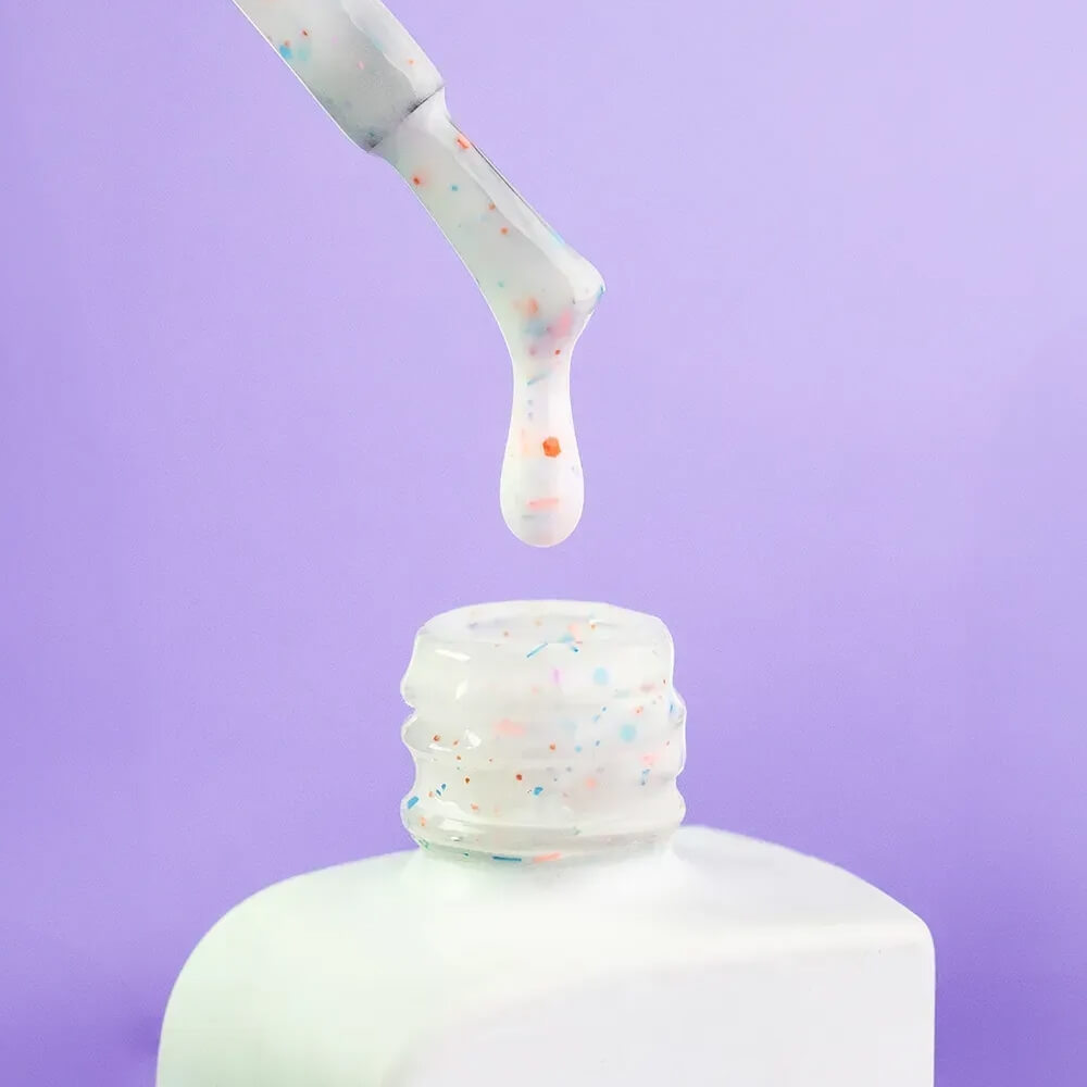The brush and cap removed from the 30ml Inspiration bottle, colorful flecks visible on the applicator