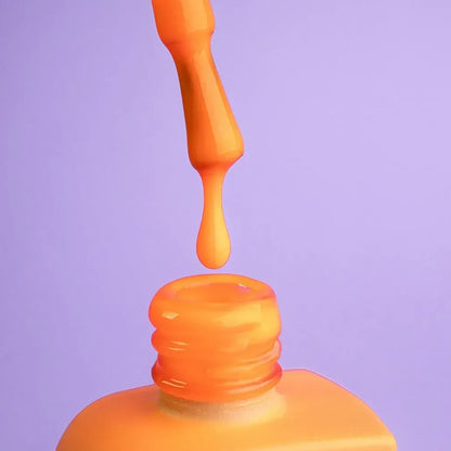 12ml bottle of Aperol in vibrant orange next to a DNKa top coat bottle