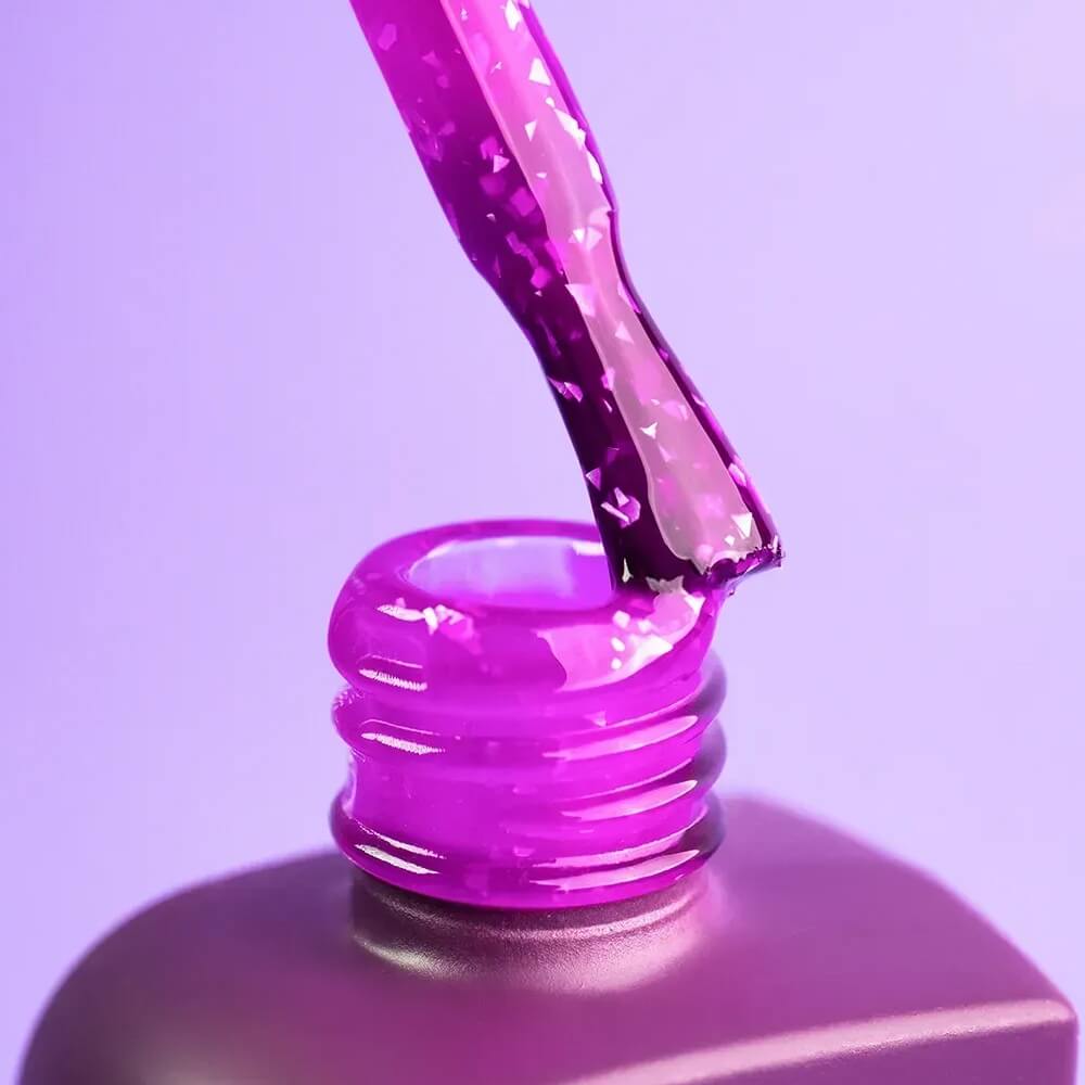 The Courage brush lifted from an open 12ml bottle, purple and gold residue coating the bristles