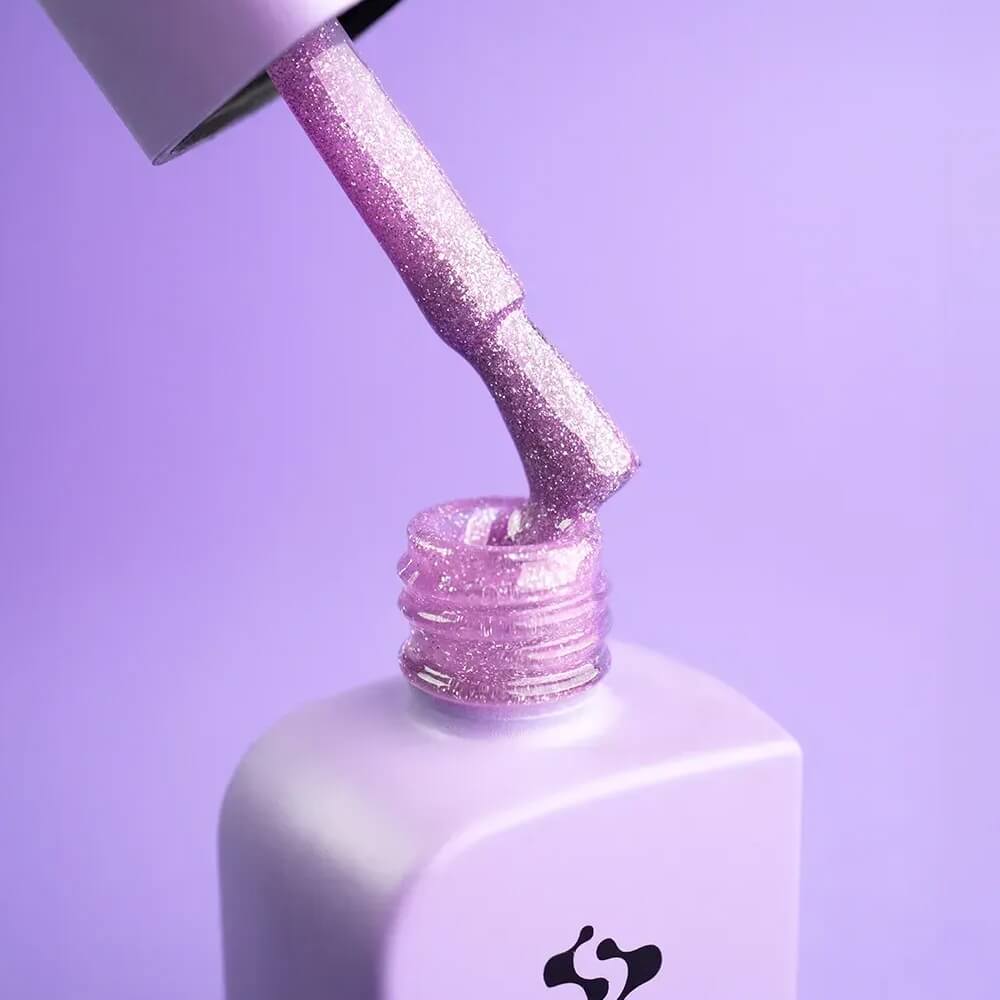 Applicator brush resting against the open Euphoria bottle, violet gel coating the bristles evenly