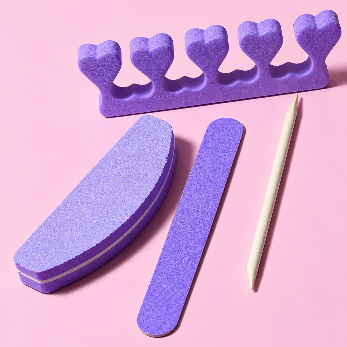 Purple toe separator, half-moon file, nail file and stick laid out