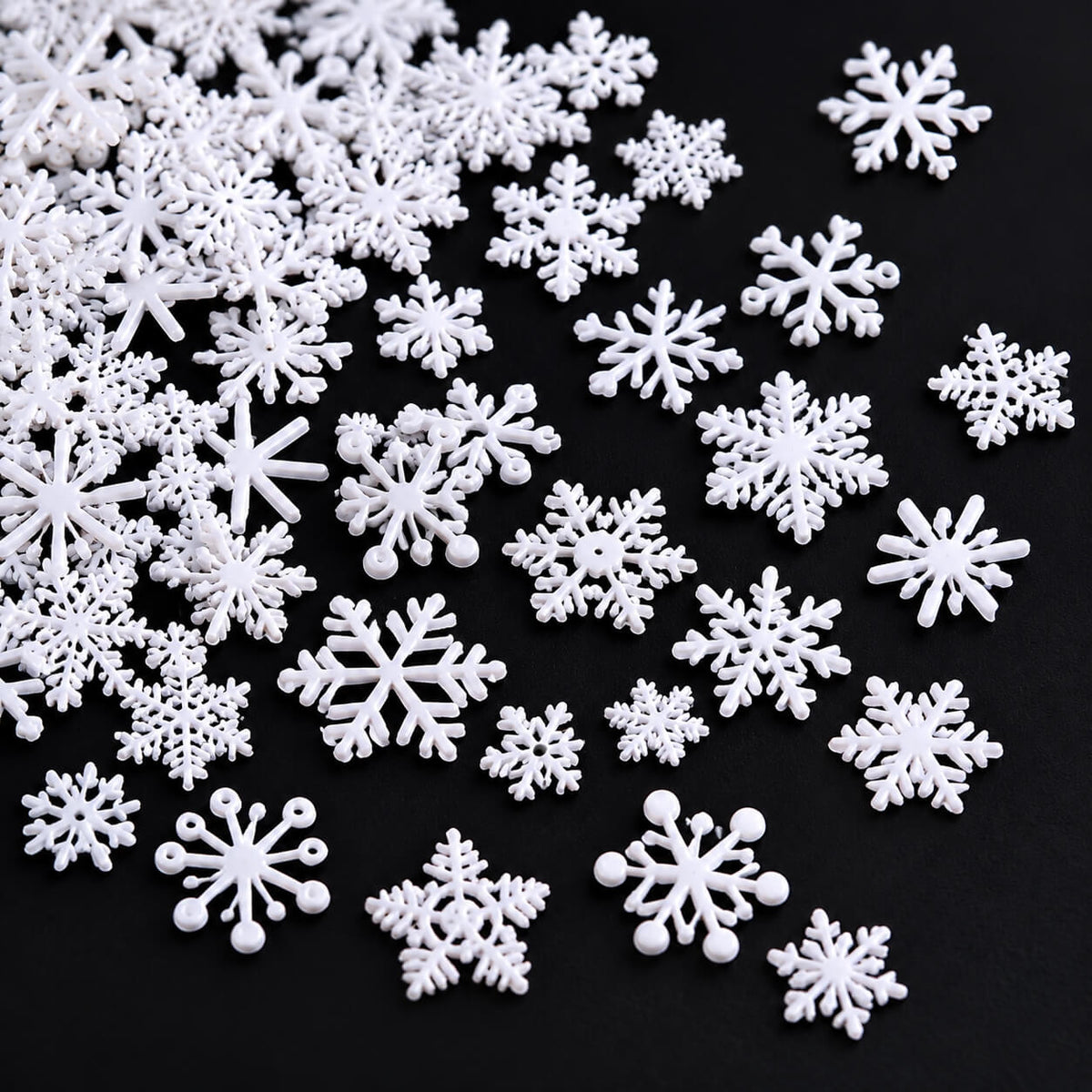 White snowflake nail decorations featuring intricate openwork designs for winter manicures